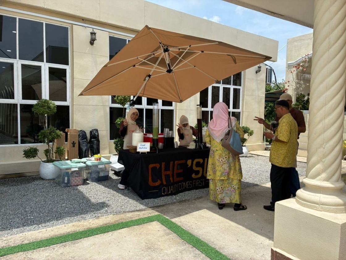 CHE'SU beverage booth set up outdoors at an event, guests arriving